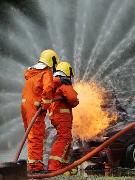 Firefighter spray water to fire burning car workshop fire traini — Stock Photo, Image