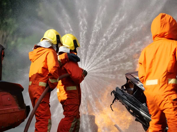 Firefighter spray water to fire burning car workshop fire traini — Stock Photo, Image