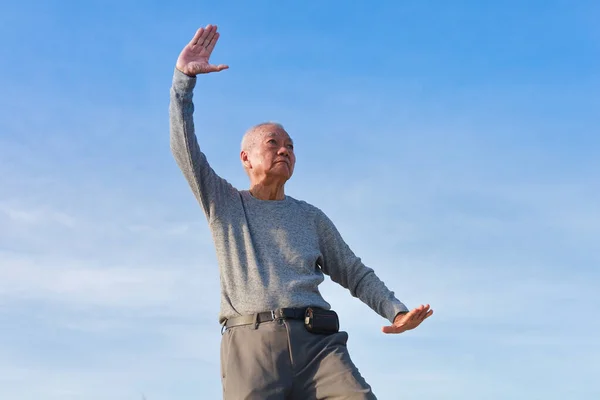 아시아 노인이 해변에서 중국의 충푸다 이치를 연습하고 로열티 프리 스톡 이미지
