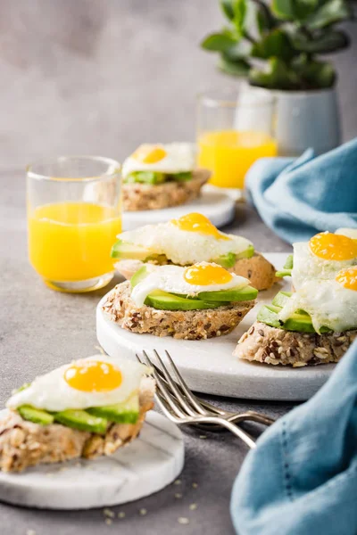 Healthy sandwich with fresh avocado and fried quail eggs — Stock Photo, Image