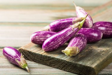 Küçük patlıcan ya da patlıcan sebze eski ahşap zemin üzerine yığını. Sağlıklı gıda kavramı kopya alanı ile.