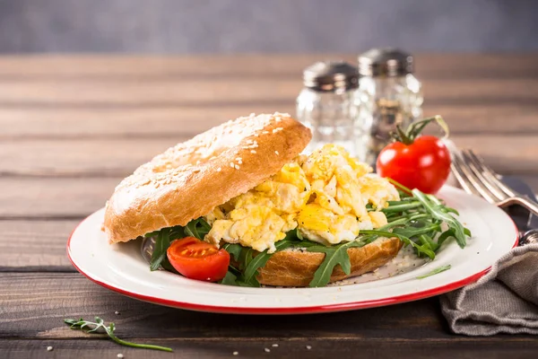 Freshly baked bagel filled with scrambled eggs — Stock Photo, Image