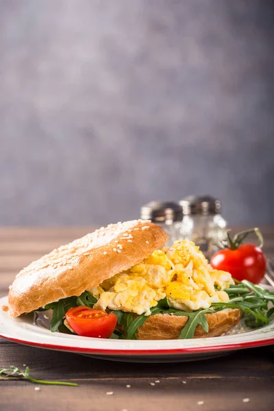 Freshly baked bagel filled with scrambled eggs — Stock Photo, Image