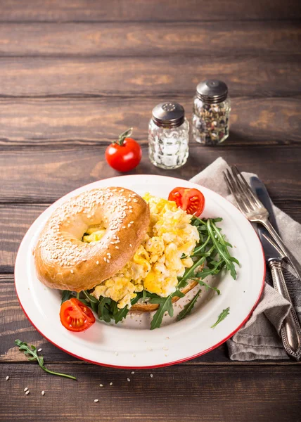 Freshly baked bagel filled with scrambled eggs — Stock Photo, Image