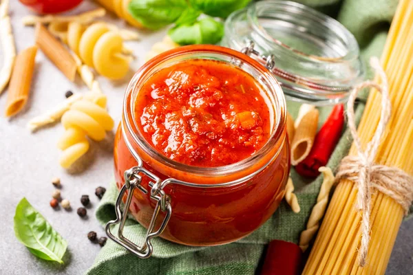 Glass jar with homemade classic spicy tomato pasta or pizza sauce.