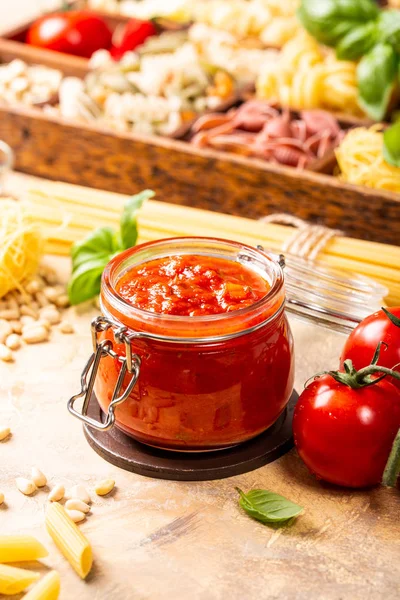 Glazen pot met zelfgemaakte klassieke pikante pasta of pizza tomatensaus. — Stockfoto