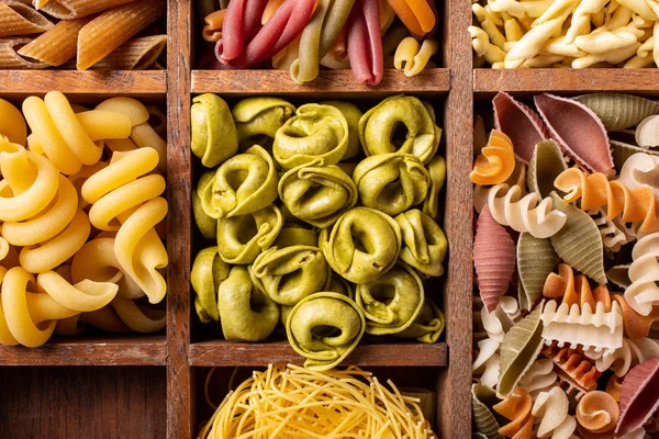 Surtido de pasta italiana colorida en caja de madera — Foto de Stock