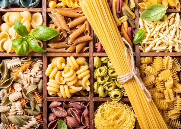 Assorted colorful italian pasta in wooden box — Stock Photo, Image