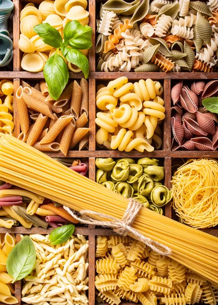 Assorted colorful italian pasta in wooden box — Stock Photo, Image