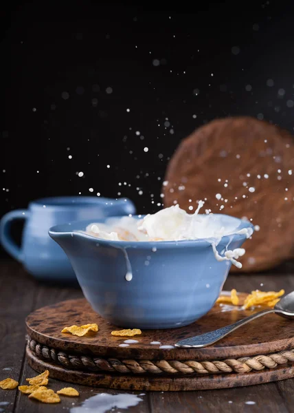 Cuenco azul de copos de maíz con salpicadura de leche — Foto de Stock