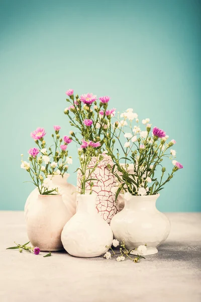 Vases with beautiful flowers on light table — Stock Photo, Image