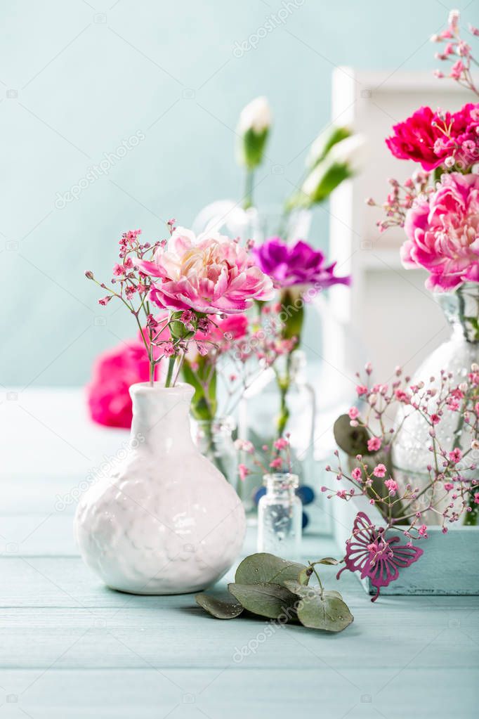 Bouquet of pink carnation on light turquoise wooden background