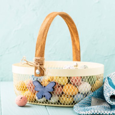 Renkli Paskalya bıldırcın yumurtası ile metal sepet