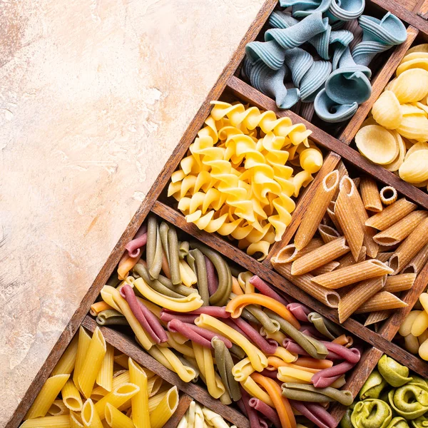 Ahşap kutusunda çeşitli renkli İtalyan Makarna — Stok fotoğraf