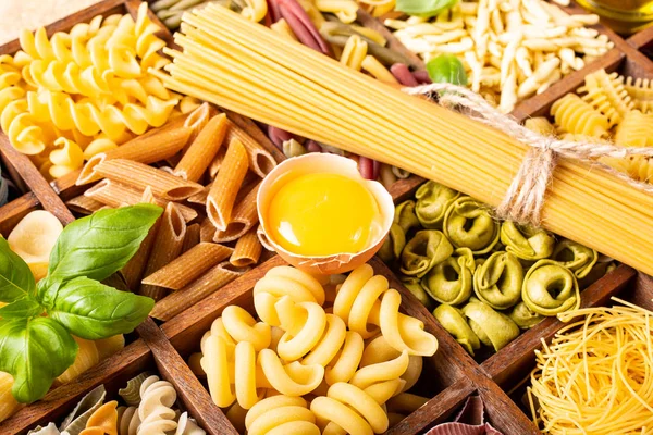 Assorted colorful italian pasta in wooden box — Stock Photo, Image