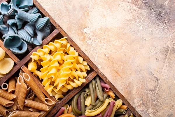 Ahşap kutusunda çeşitli renkli İtalyan Makarna — Stok fotoğraf
