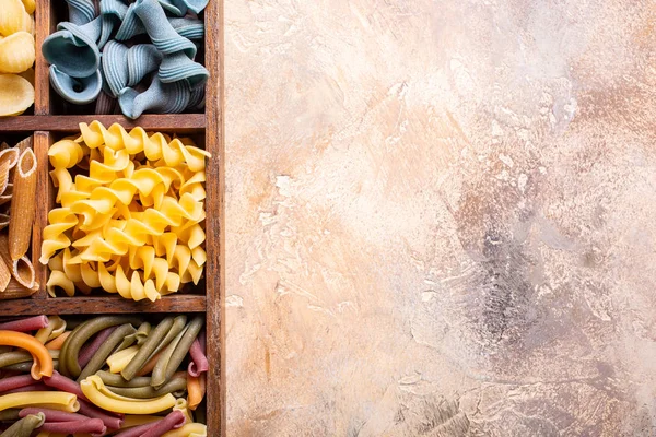 Verschiedene bunte italienische Pasta in Holzkiste — Stockfoto