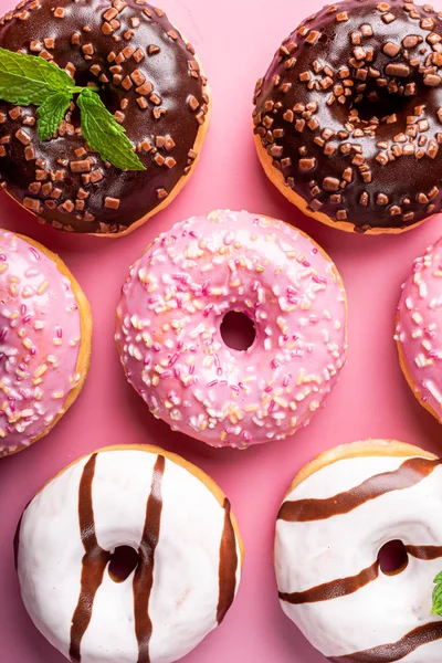 Donuts coloridos no fundo rosa — Fotografia de Stock