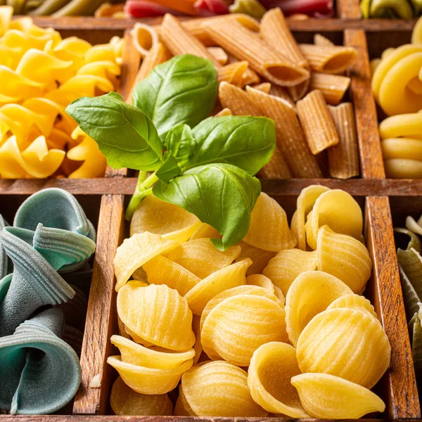 Assorted colorful italian pasta in wooden box — Stock Photo, Image
