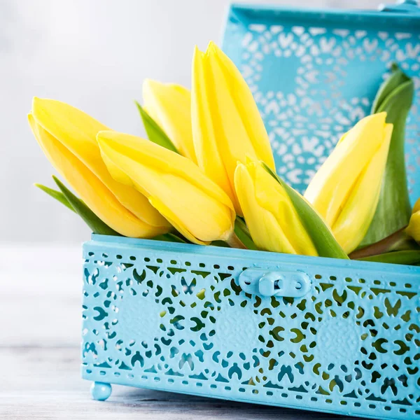 Żółte tulipany w niebieski metalowe pudełko — Zdjęcie stockowe