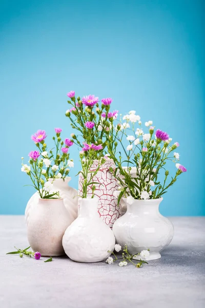 Jarrones con hermosas flores en la mesa de luz —  Fotos de Stock