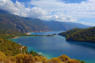 Blue Lagoon Ölüdeniz, Türkiye'de inanılmaz hava görünümünü. Dağları, yeşil orman, masmavi su, kumlu plajı ve mavi gökyüzünde parlak güneşli bir günde, yaz yatay. Arka plan seyahat. 