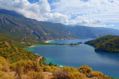 Blue Lagoon Ölüdeniz, Türkiye'de inanılmaz hava görünümünü. Dağları, yeşil orman, masmavi su, kumlu plajı ve mavi gökyüzünde parlak güneşli bir günde, yaz yatay. Arka plan seyahat. 