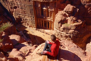 Oturan genç bir adamla hazine yukarıdan. Petra, Jordan, UNESCO Dünya Miras Listesi antik kentinde Al Khazneh