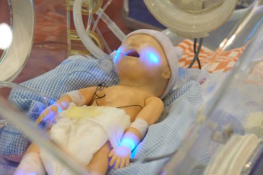 Infant dummy in neonatal intensive-care unit for medical students study clipart