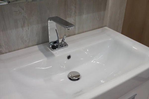 白セラミック洗面台とバスルームでミキサーの金属を嵌め込む式 ストックフォト