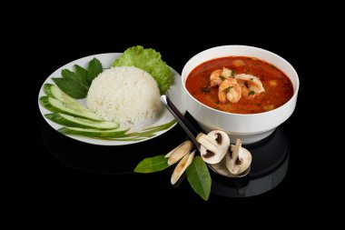 Tom yum veya tom yam genellikle pişmiş karides ile sıcak ve ekşi Tay çorba türüdür. Pirinç, sebze ve yemek çubukları ile servis. Siyah yansıtıcı arka planda izole.
