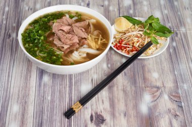 Vietnamca şehriye çorbası Pho bo ahşap zemin üzerine tabak