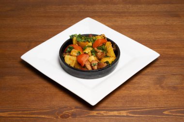 Kahverengi ahşap masa üzerinde Gürcü mutfağı yemek. Kızarmış domuz eti, patates karınca domates.