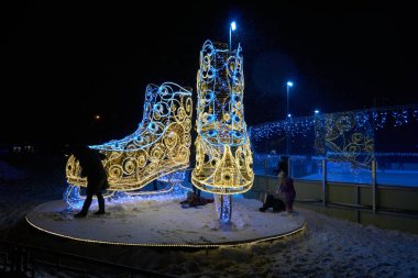 Moskova, Rusya - 02 Ocak 2019: Büyük led ışık çifti açık havada yeni buz pateni halka Moskova Medvedkovo bölgesinde geceleri kaymaktadır. Çocuk yakın oyun.