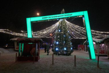 Moskova, Rusya - 02 Ocak 2019: Kış ışık süslemeleri kürk ağaç açık havada Medvedkovo bölgesinde gece yeni yıl tatilinde olanağını sağladı. Rus metin yeşil led ışık stand: Olonetskiy geçiş meydanda.