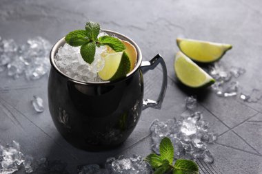 Alkolik içecekler. Mojito kokteyli. Limonlu, buzlu ve açık gri arka planda naneli bir bardakta kokteyl. Yatay olarak. Arkaplan resmi, alanı kopyala