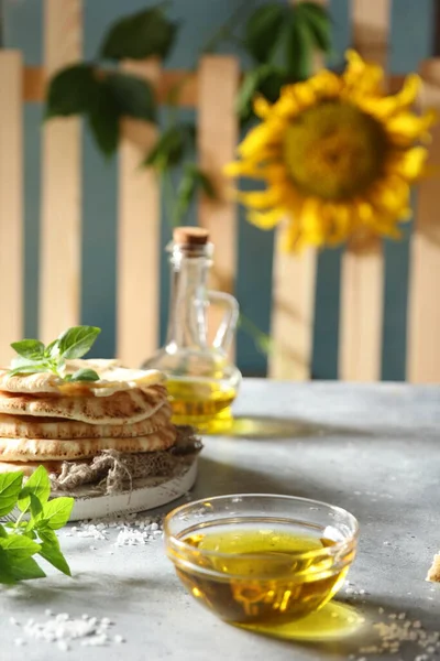 橄榄油在一个大的透明碗 盐和玉米片在一个轻薄的桌子上 村庄的历史 篱笆和向日葵背景图像 复制空间 — 图库照片