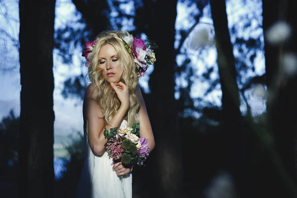 花束を保持している長い髪と花ヘアバンドと美しさの女性 目を閉じながら日光によって浮き出てロマンチックなスタイルでポーズをとっての花嫁 — ストック写真