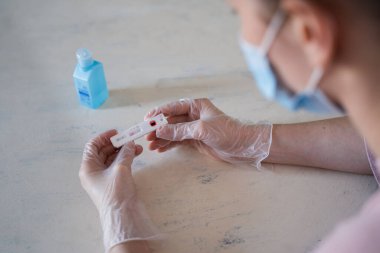 Endişeli bir kadının odak arkaplanından sonuçları beklediği kısa bir covid-19 testi..