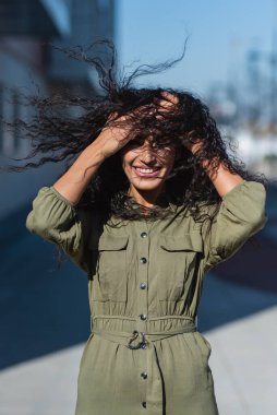 Güzel bir kadının rüzgar saçı, şehir arka planında açık havada.