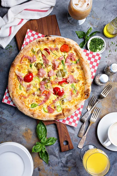 Kahvaltı pizza çırpılmış yumurta, jambon ve domates ile