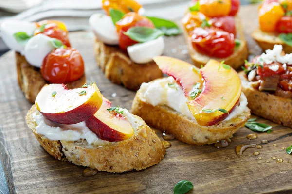 Crostini or bruschetta board with caprese, tomatoes and peaches — Stock Photo, Image