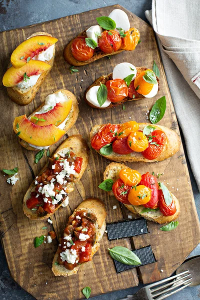 Crostini or bruschetta board with caprese, tomatoes and peaches — Stock Photo, Image