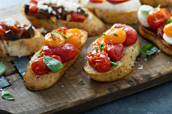 Crostini or bruschetta board with roasted tomatoes and herbs — Stock Photo, Image