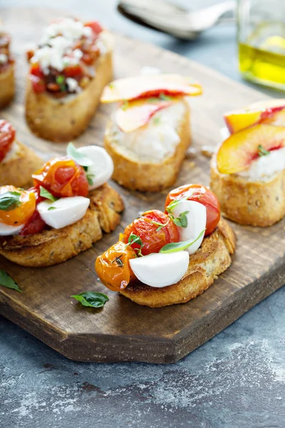 Crostini or bruschetta board with caprese made with roasted tomatoes — Stock Photo, Image