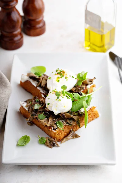 Torrada de pequeno-almoço com cogumelos e ovos escalfados — Fotografia de Stock