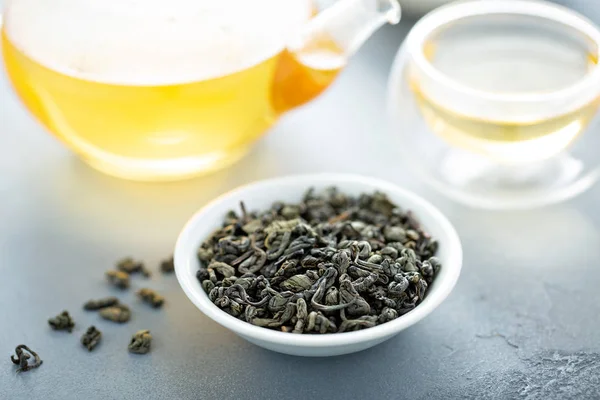 Green loose leaf tea and a teapot — Stock Photo, Image