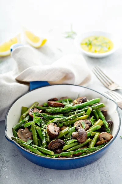 Asparagus and mushrooms in a cast iron pan — Stock Photo, Image