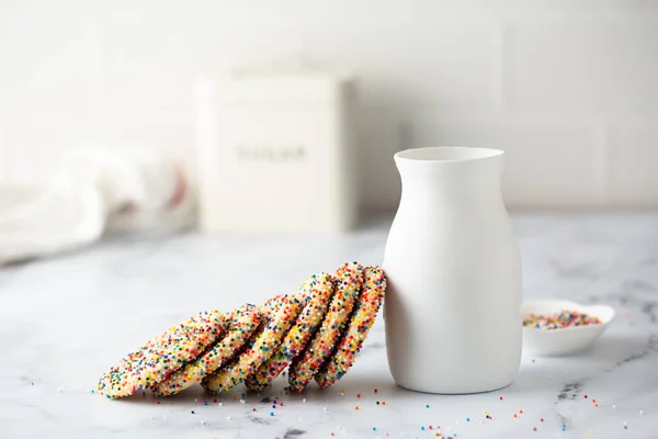 Sugar cookies with sprinkles and a bottle of milk — Stock Photo, Image