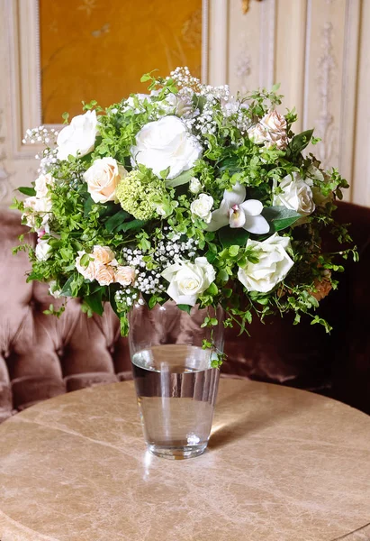 Bouquet of white roses on marble table in interior of the Baroque style